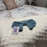 Towel art folded into a character with googly eyes on a made bed at a vacation rental cleaned by Lee Lapid Housekeeping in Marathon FL