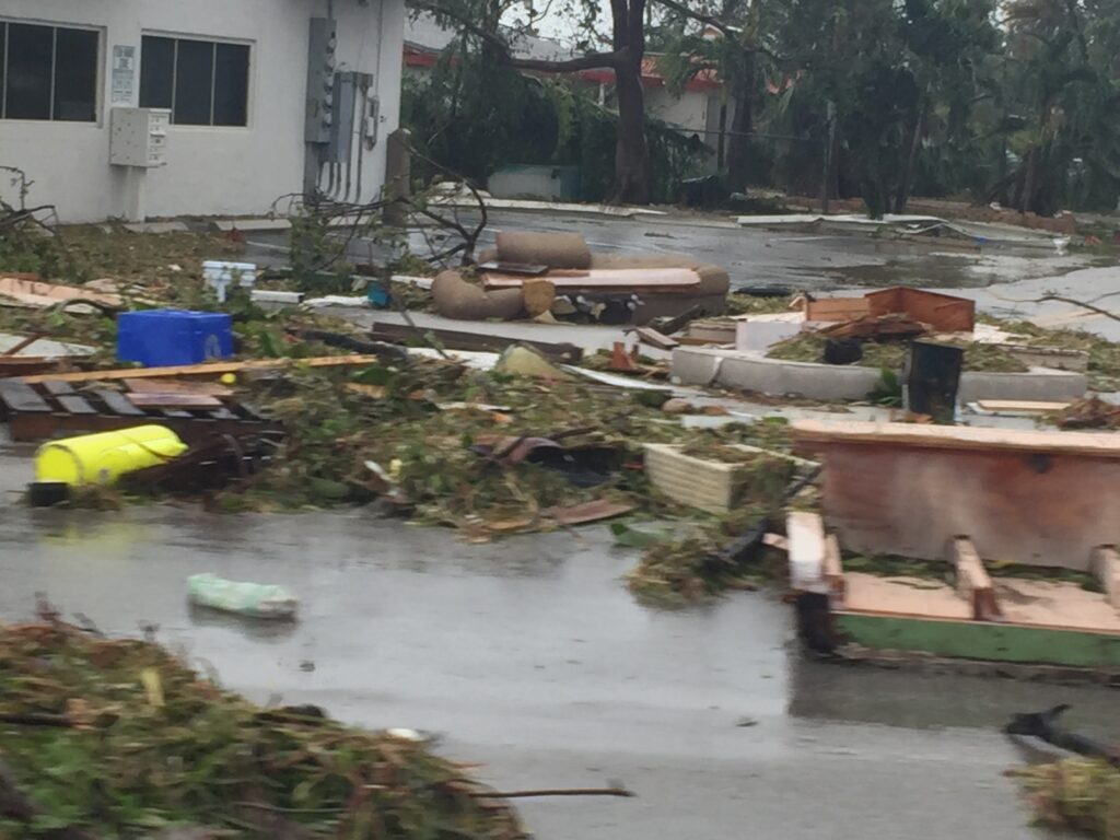 Hurricane damage aftermath showing debris scattered across property